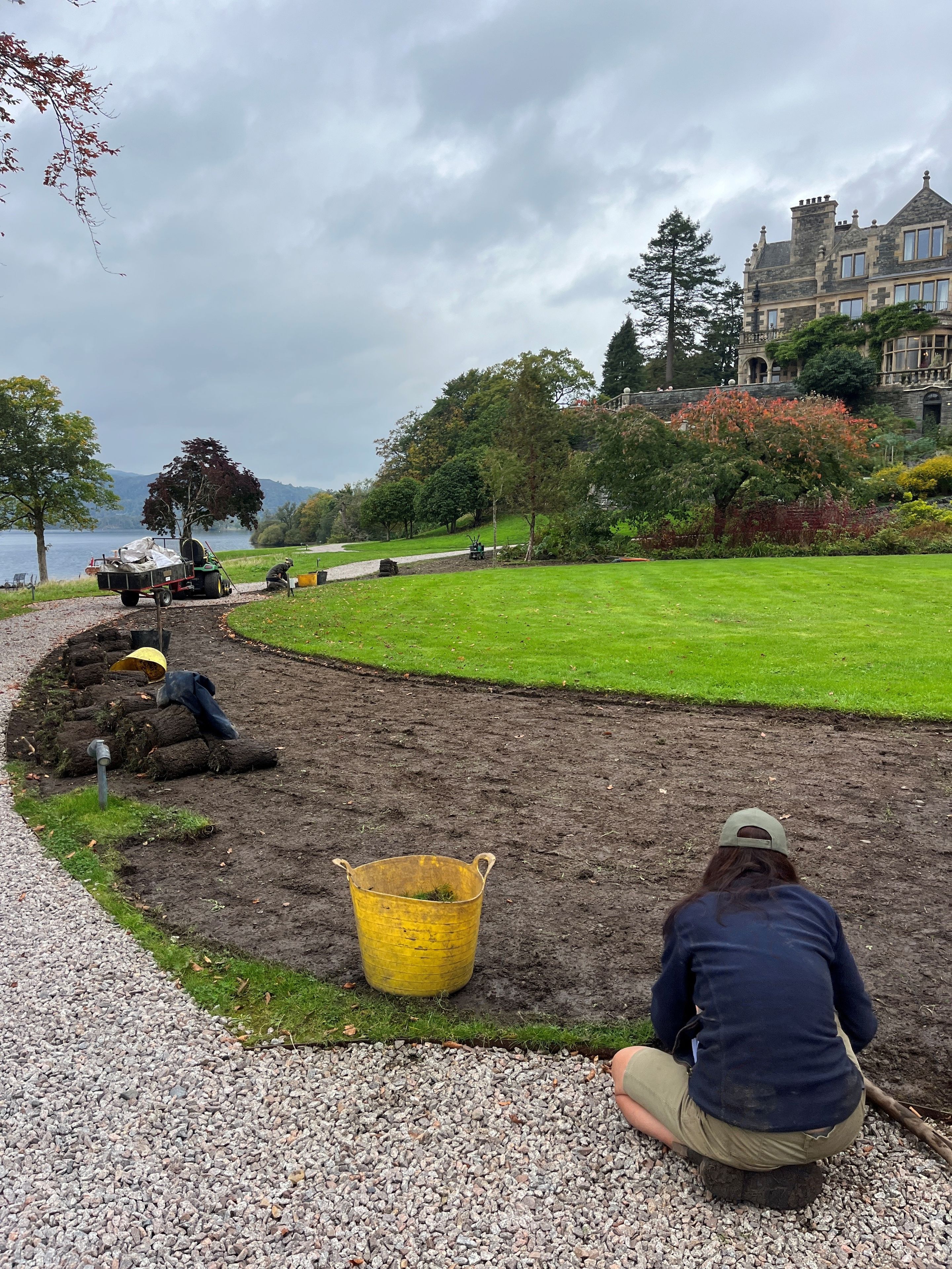Gardeners adding fresh soil to main lawn