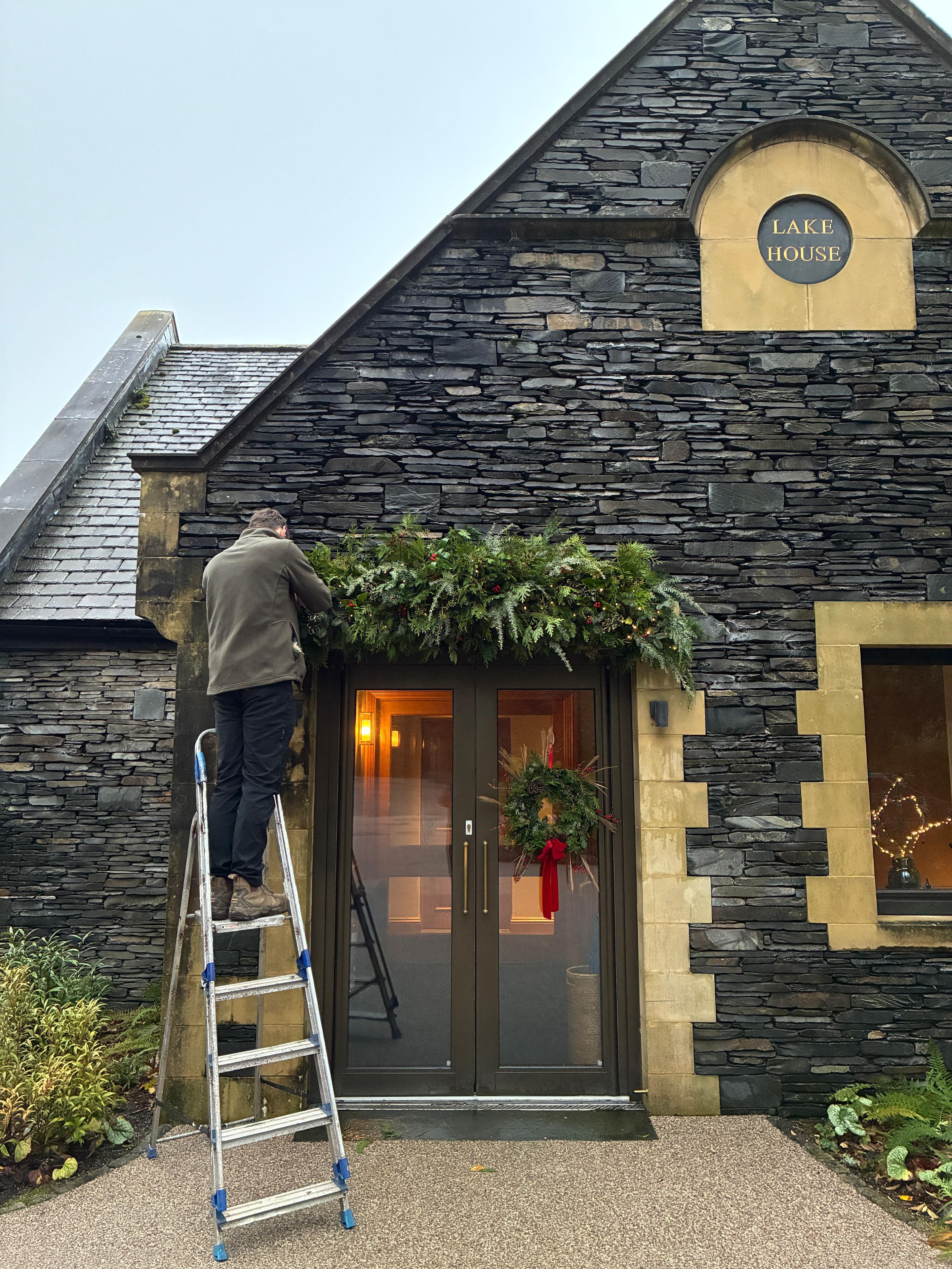 Staff at Langdale Chase hanging a garland on the Lakehouse
